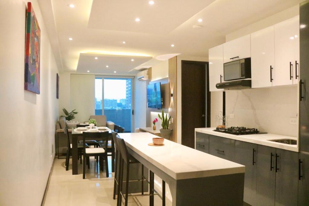 a kitchen with white cabinets and a dining room at Atlantis Suites Bquilla -Apartamento Moderno-2-BD in Barranquilla