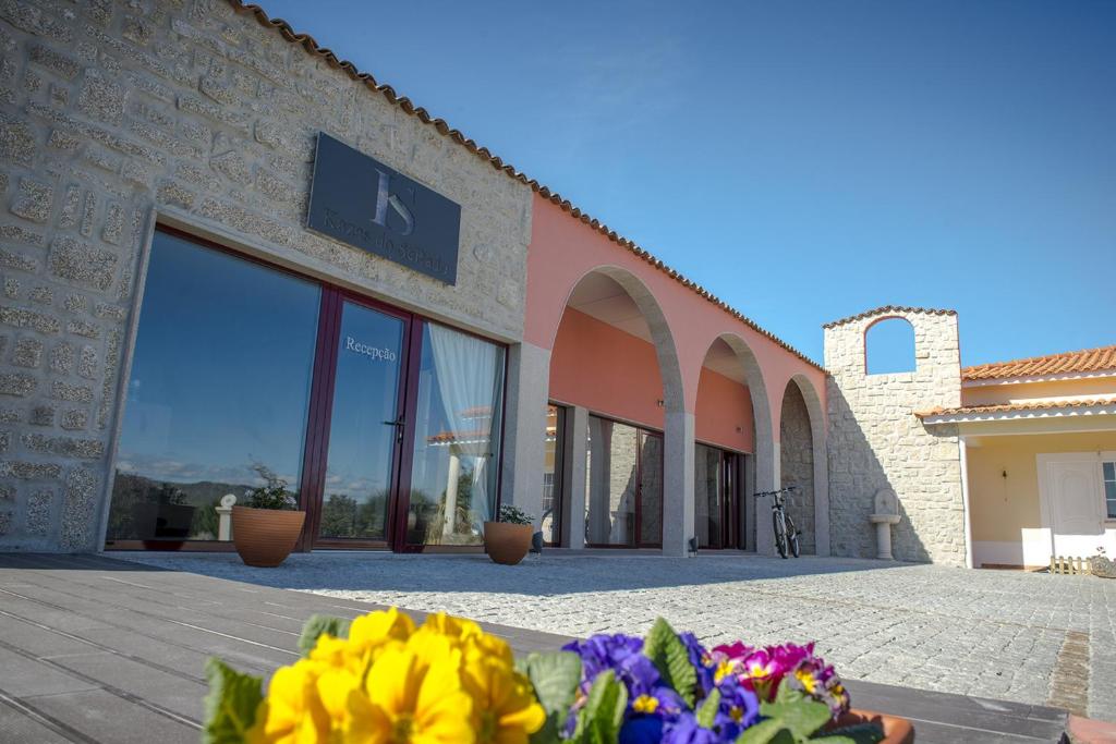 a building with a bunch of flowers in front of it at Kazas do SeRado in Caria