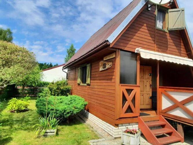 a wooden cabin with a door and a window at A comfortable house with a private garden, Rusinowo in Rusinowo