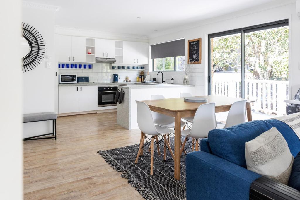a kitchen and living room with a table and chairs at Pet and family friendly- with its own lake and 3 mins from town! in Maleny