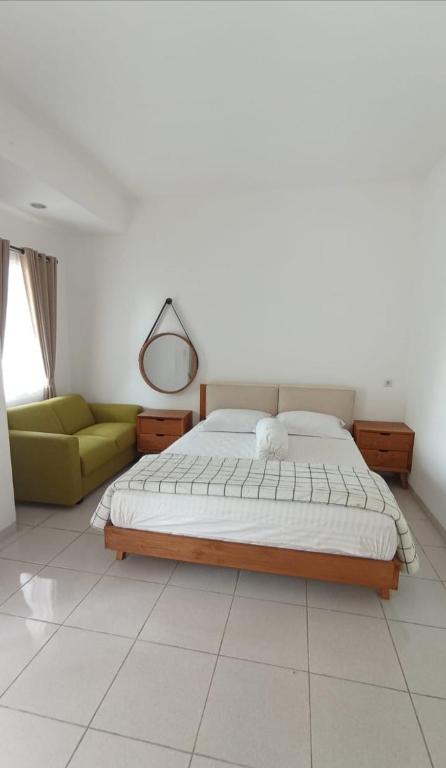 1 dormitorio con cama y sofá amarillo en Kost eksklusif Gondang & Guest House, en Srondolwetan