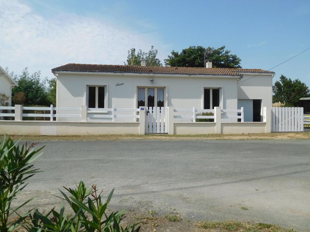 a small white house with a white fence at Maison spacieuse 6 pers. près plage avec jardin - FR-1-476-204 in La Faute-sur-Mer