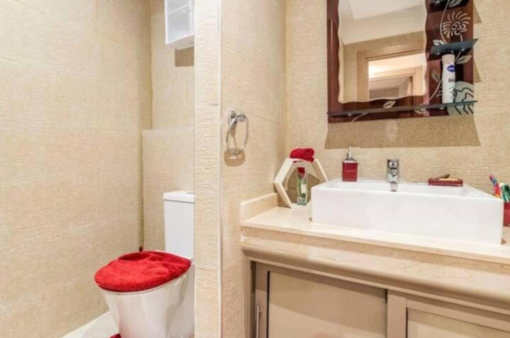 y baño con lavabo, aseo y espejo. en Magnifique appartement Les perles de marrakech lux avec 2 piscines, en Marrakech