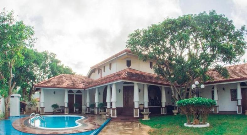 une maison avec une piscine en face de celle-ci dans l'établissement Olideb Gedara, à Negombo