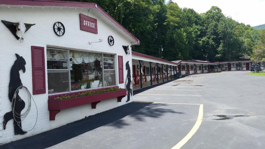 a white building with clocks on the side of it at A Holiday Motel - Maggie Valley in Maggie Valley