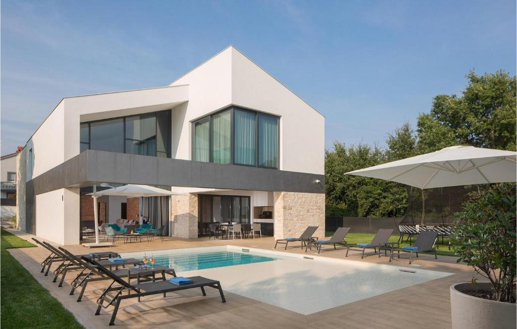 a house with a swimming pool in front of it at Villa Eden in Ližnjan