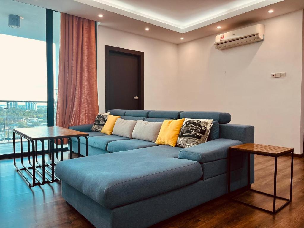 uma sala de estar com um sofá azul e uma mesa em D Beep Beep Homestay Vivacity Homestay em Kuching