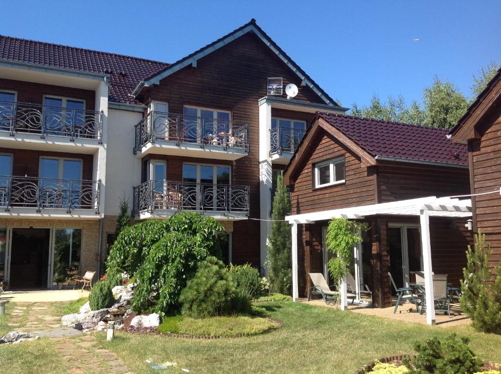 a large house with a yard in front of it at Sekret Łeba Dom i Domki in Łeba