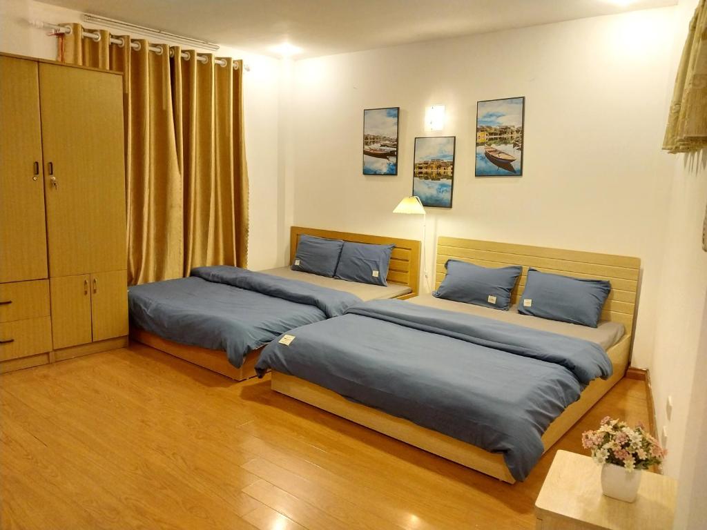 sypialnia z 2 łóżkami i niebieskimi poduszkami w obiekcie Da Tree Homestay w mieście Hanoi