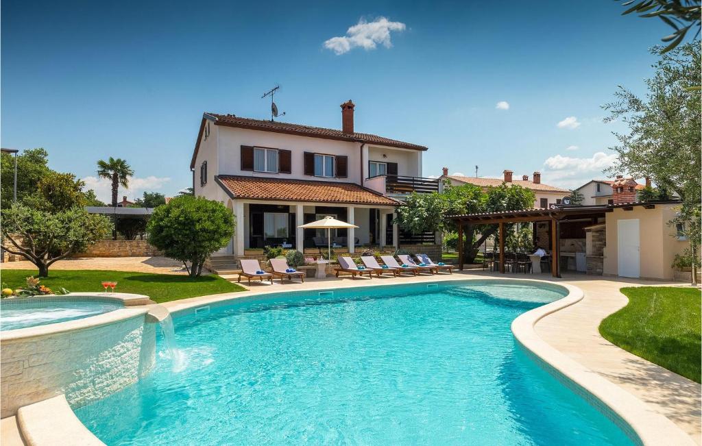 a swimming pool in front of a house at Villa David in Poreč