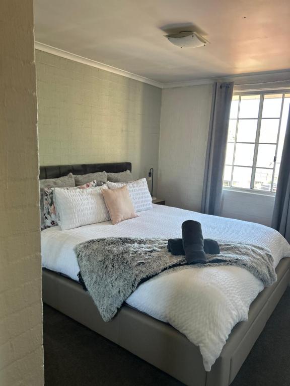 a bedroom with a large bed with a hat on it at Plush 2 bedroom apartment Kingston in Kingston 