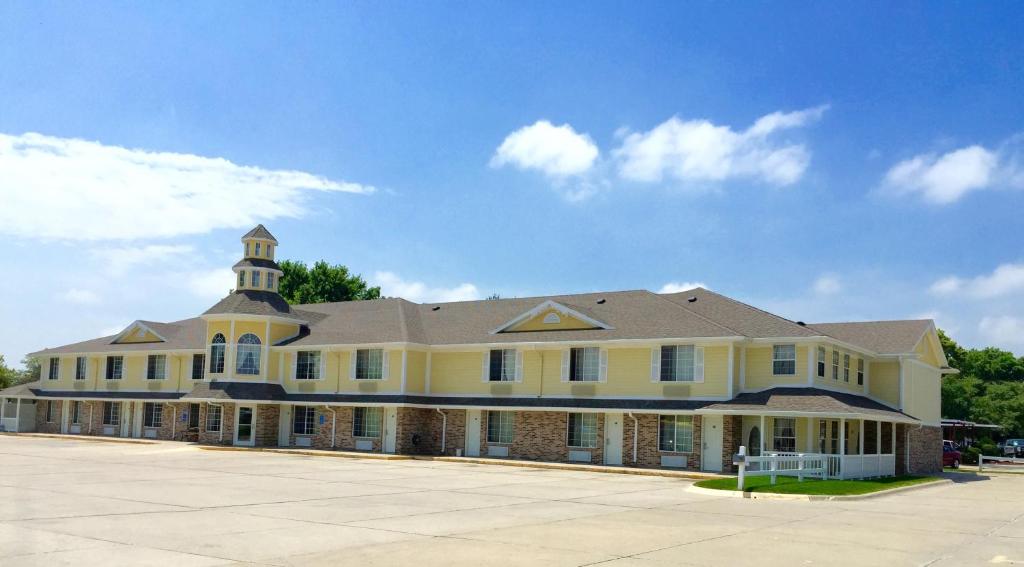 a large yellow building with a clock tower on top at Platte Valley Inn in Columbus