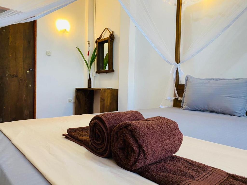 a bedroom with a bed with towels on it at Avalon in Weligama