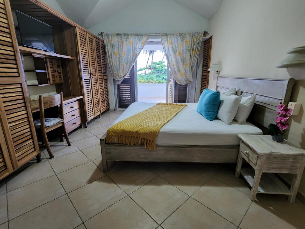 a bedroom with a large bed and a window at Hoteles Josefina Las Terrenas in Las Terrenas