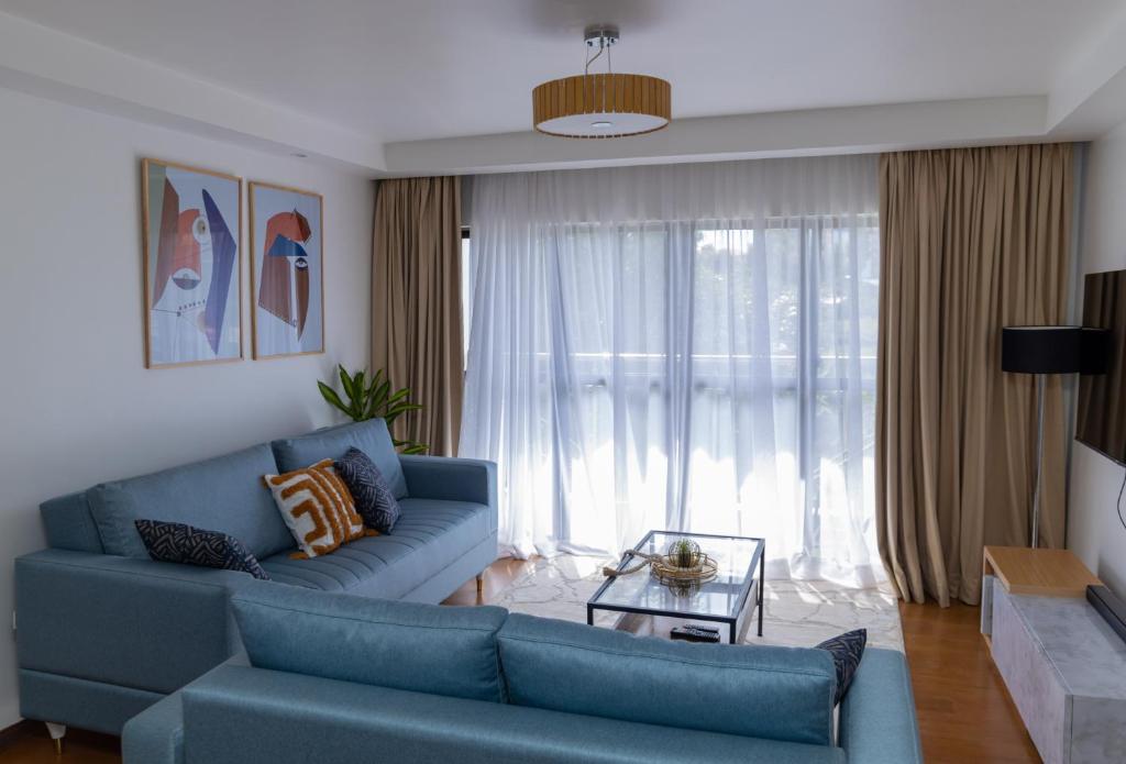 Ruaka的住宿－Ruaka Radiance 2-Bed Escape，客厅配有蓝色的沙发和桌子