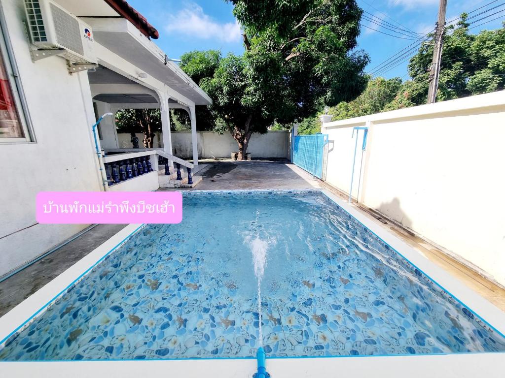 uma piscina numa casa com uma fonte de água em Mae Rampung Beach House คาราโอเกะและสระเด็ก em Rayong