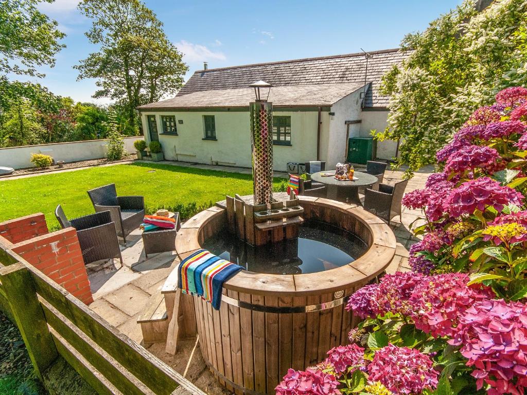 a backyard with a hot tub with a fountain at Yr Hen Glowty in Little Newcastle