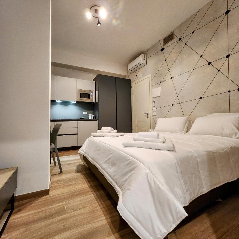 una camera con un grande letto bianco e una cucina di b&b marconi 49 a Bologna