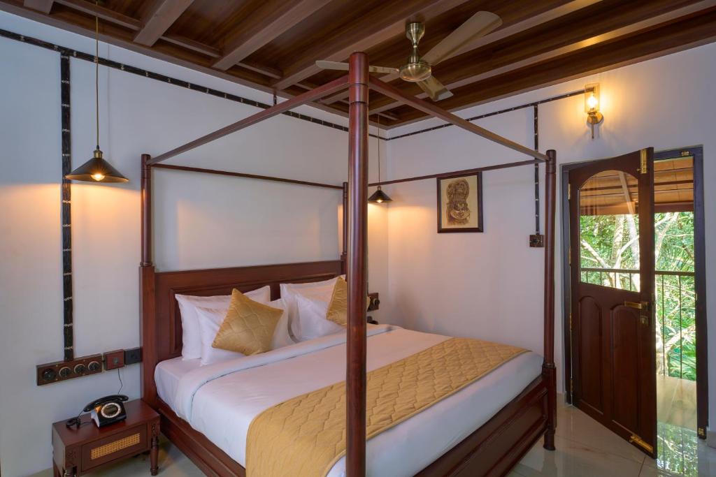 a bedroom with a canopy bed in a room at Malabar Kovilakam in Malappuram
