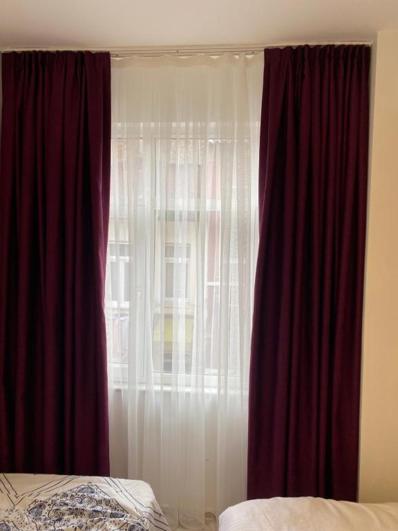 a bedroom with a window with red curtains at yenikapı hotel in Istanbul
