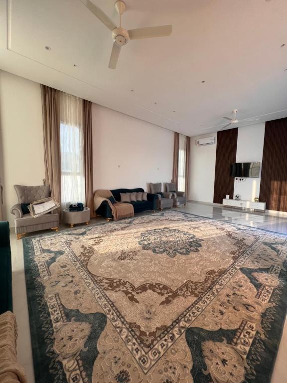 a living room with a large rug on the floor at Monsoon Chalet - شاليه المونسون in Junayz al Janūbī