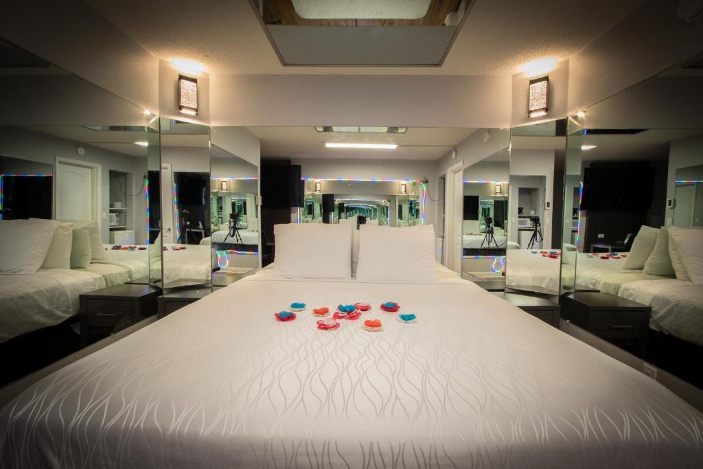 a large white bed with glasses on top of it at Envi Boutique Hotel in Henderson