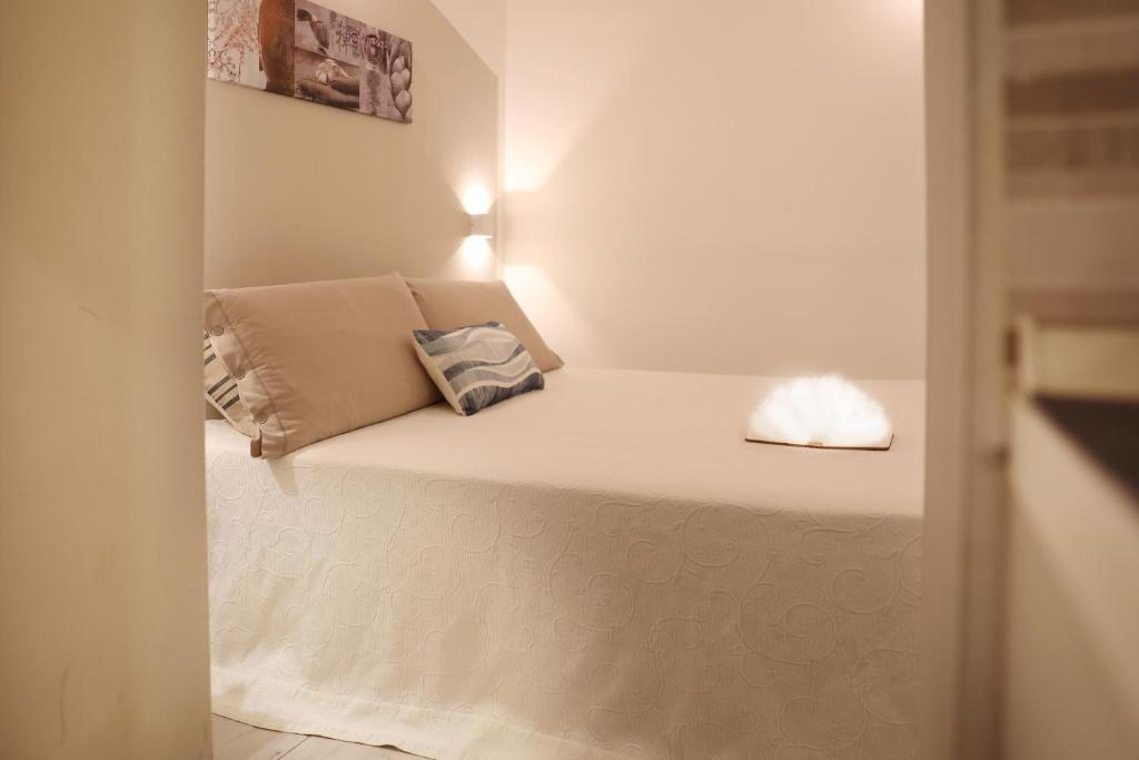 Łóżko w małym pokoju z poduszką w obiekcie La Corte di Santa Maria w mieście Sassari