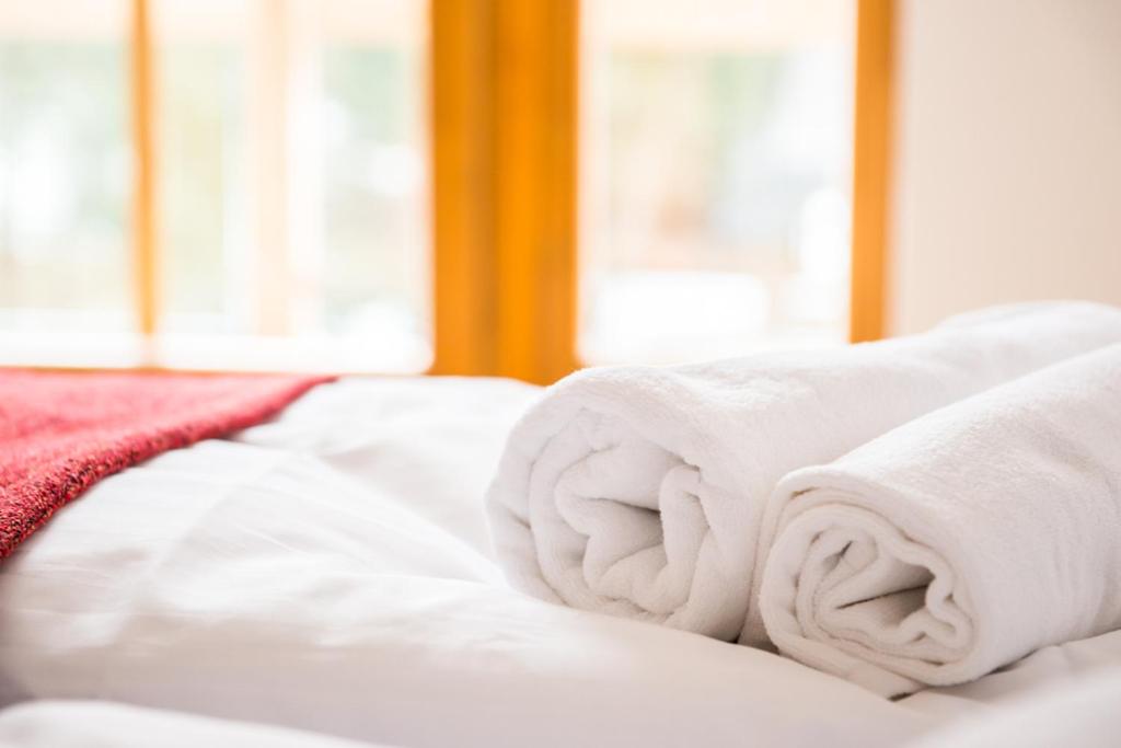 a pile of towels sitting on top of a bed at Stara Chata w Beskidach in Żabnica