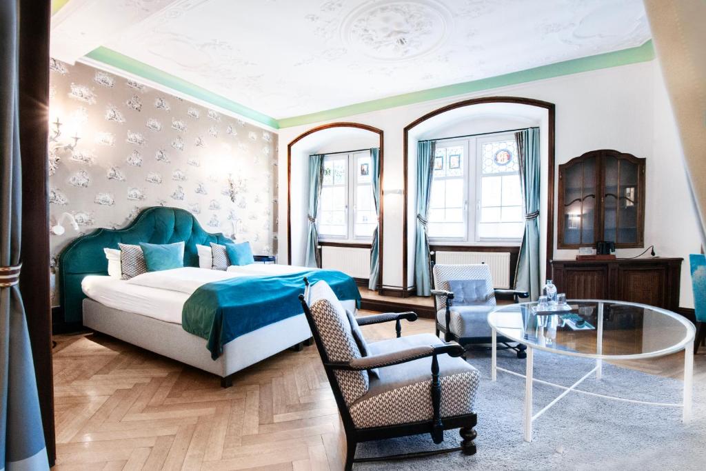 a bedroom with a bed and a glass table at Romantik Hotel Barbarossa in Konstanz