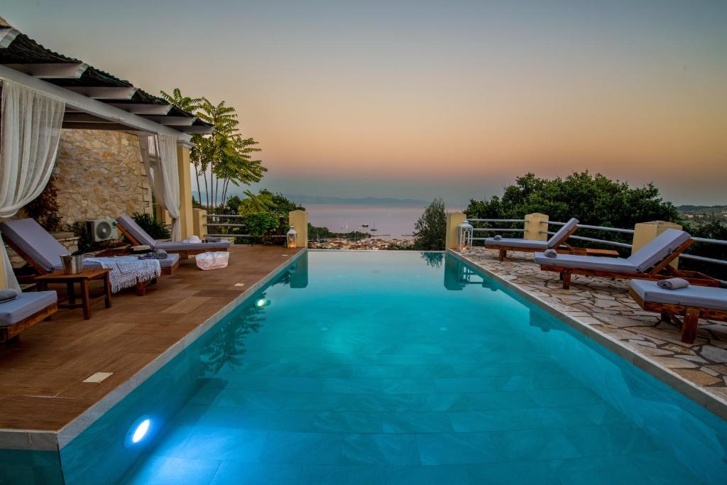 a swimming pool with a view of the ocean from a villa at Red Rose Artistsvillas in Gaios