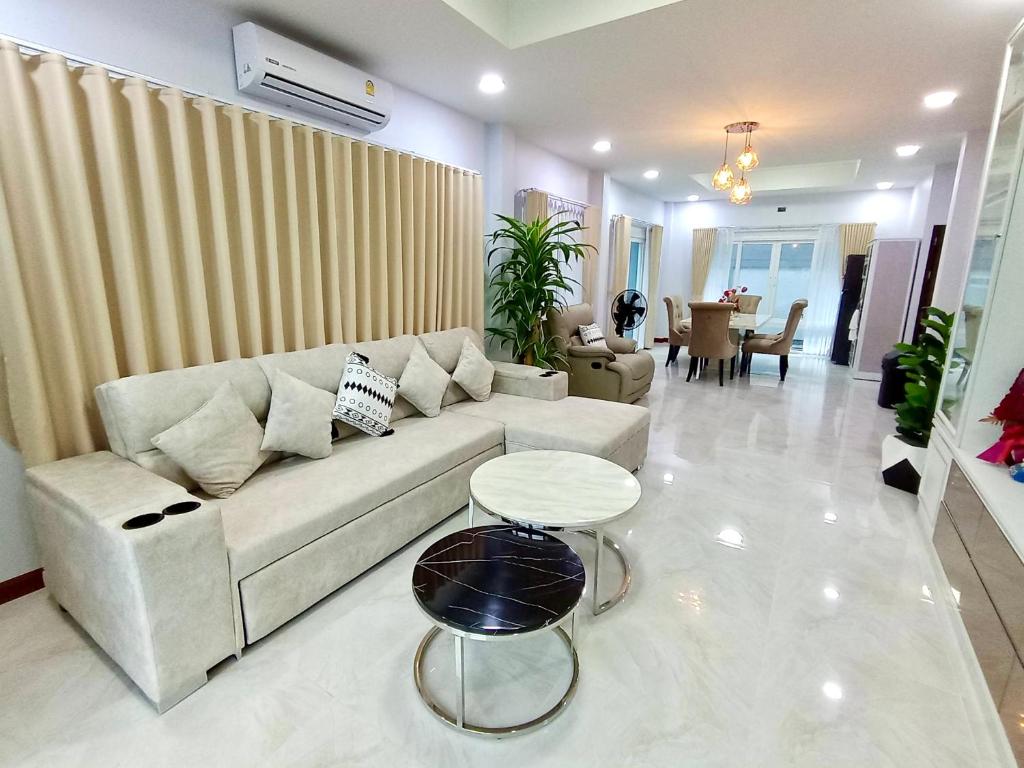 een woonkamer met een bank en een tafel bij Pause Homestay in Ban Khlong Wa