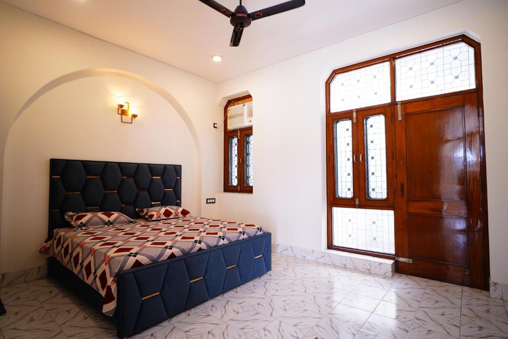 a bedroom with a bed and a large window at Madaan Villas in New Delhi