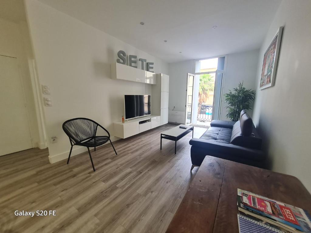 un salon avec un canapé et une télévision dans l'établissement Notre cœur de ville douillet, à Sète
