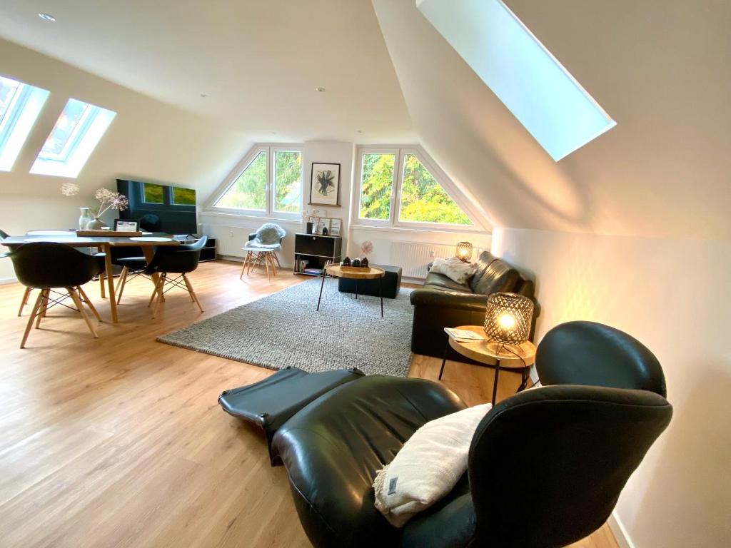 een woonkamer met een leren bank en een tafel bij Harzpur Lodge - Pure Entspannung in purer Natur in Hahnenklee-Bockswiese