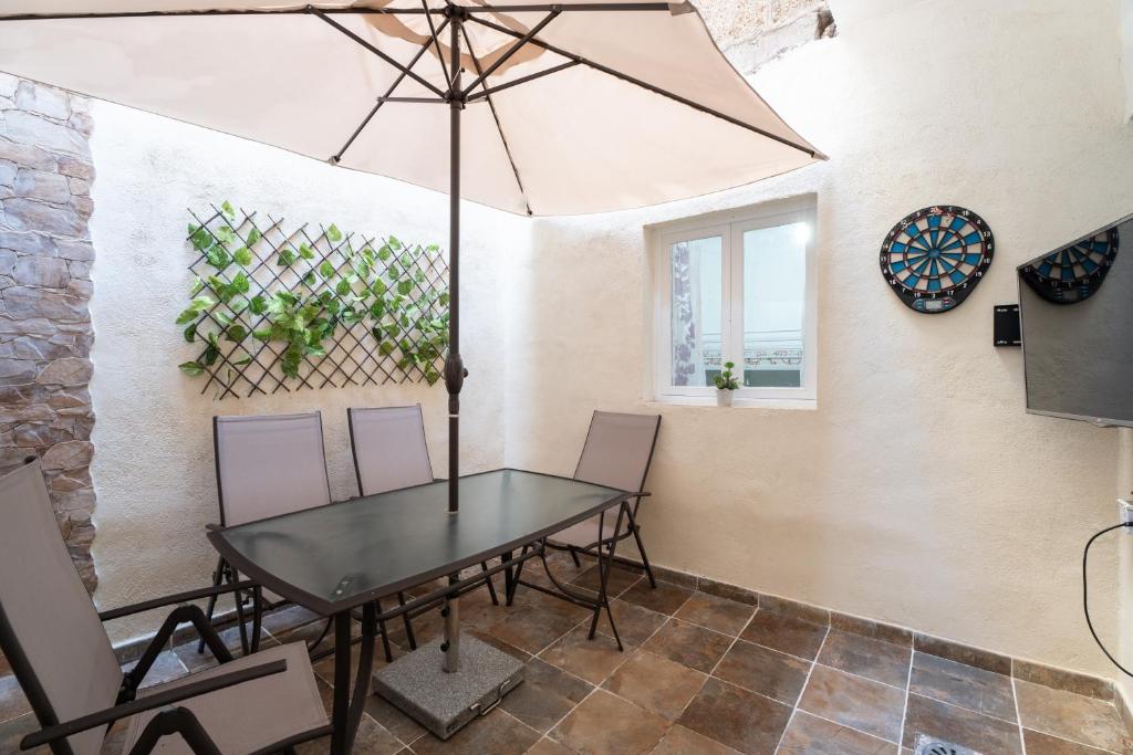 uma sala de jantar com uma mesa e cadeiras e um guarda-sol em Branmi House Barranco Grande em Santa Cruz de Tenerife