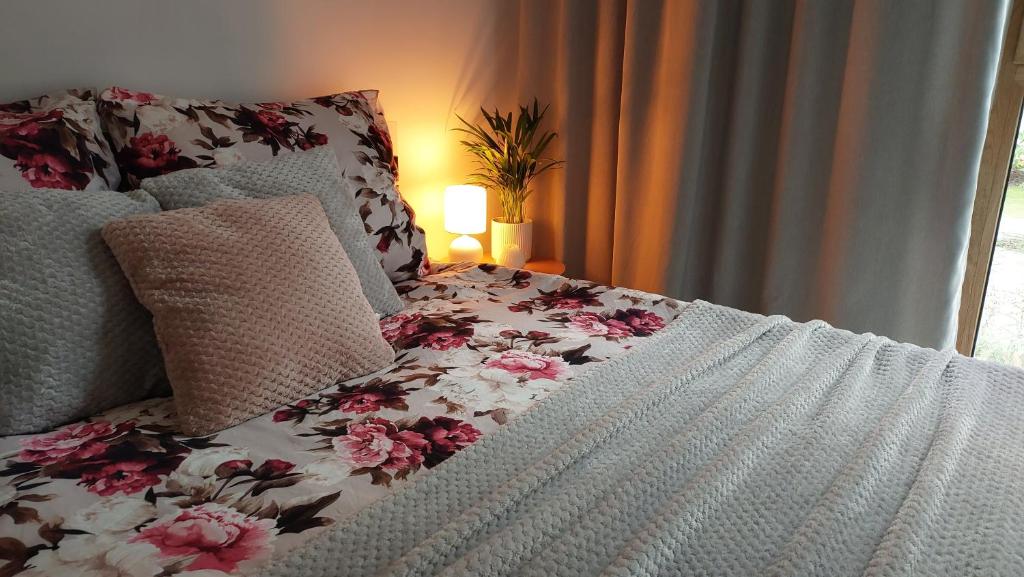 1 cama con manta blanca y rosa y lámpara en Apartment Mokotów blisko lotniska Chopina, en Varsovia