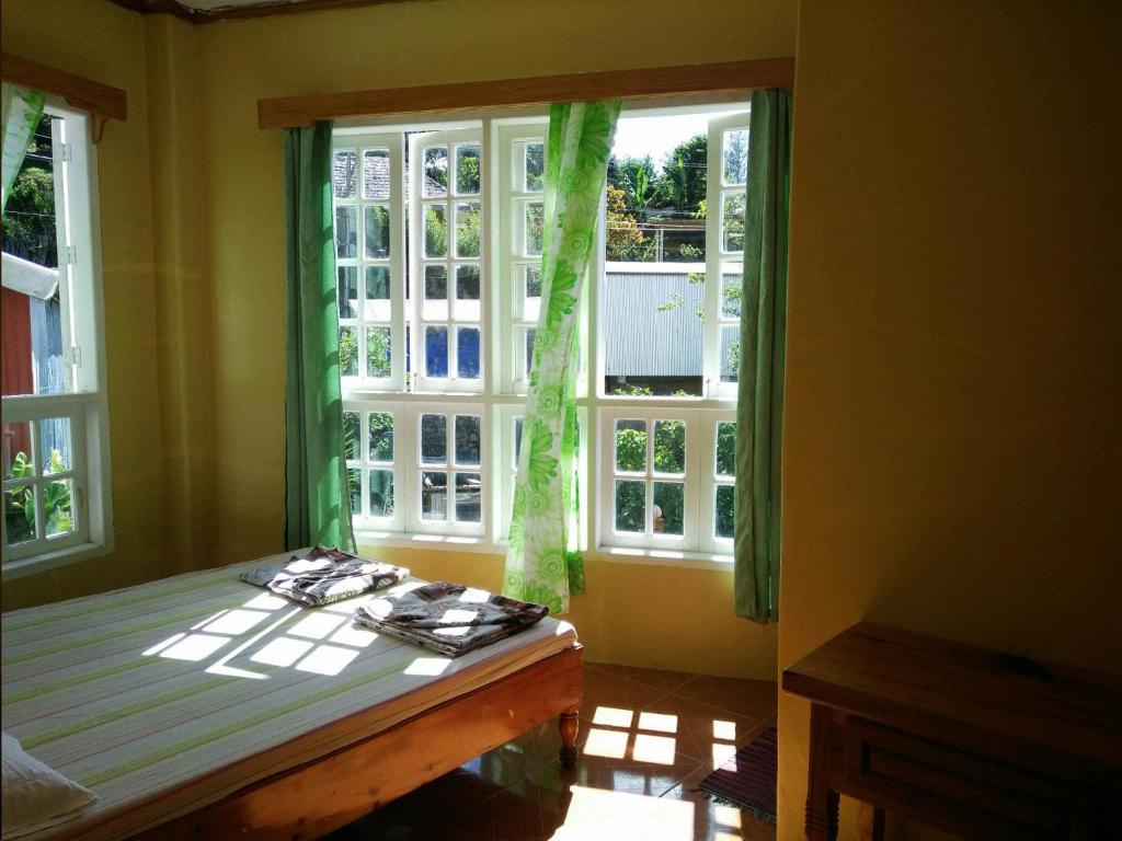 a bedroom with a bed and a large window at TRIPLE JS INN-SAGADA in Sagada