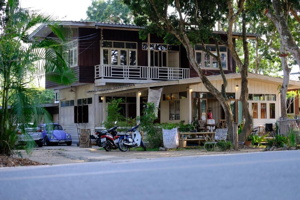 uma casa com uma scooter estacionada em frente dela em Yor Song Hostel Pai em Kampong Huaibū