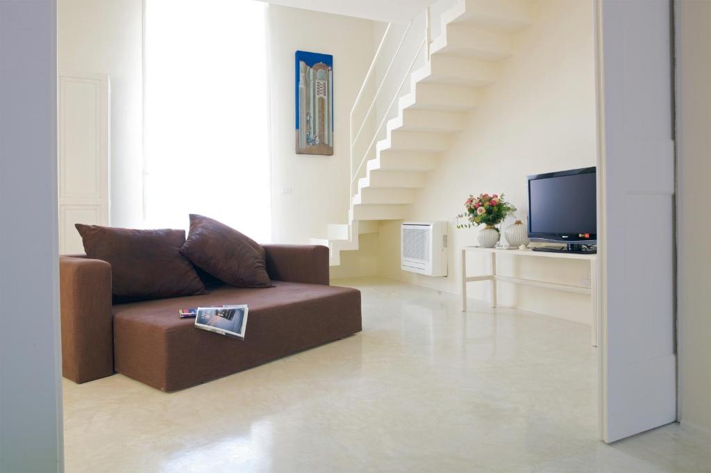 a living room with a couch and a staircase at Casa di Lo Suites in Lecce
