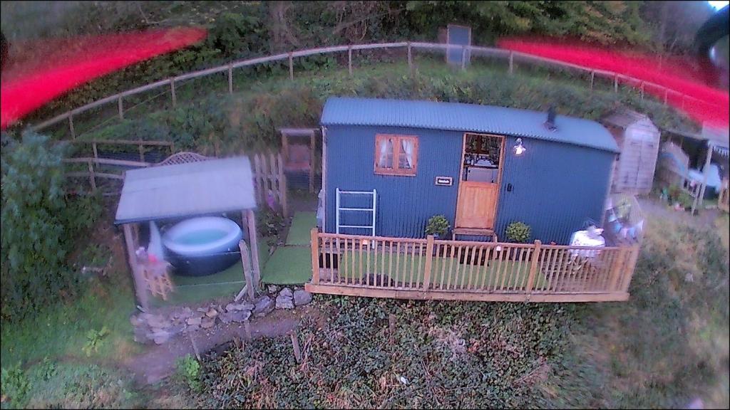 an aerial view of a blue tiny house with a porch at Llangollen Shepherds Huts in Llangollen