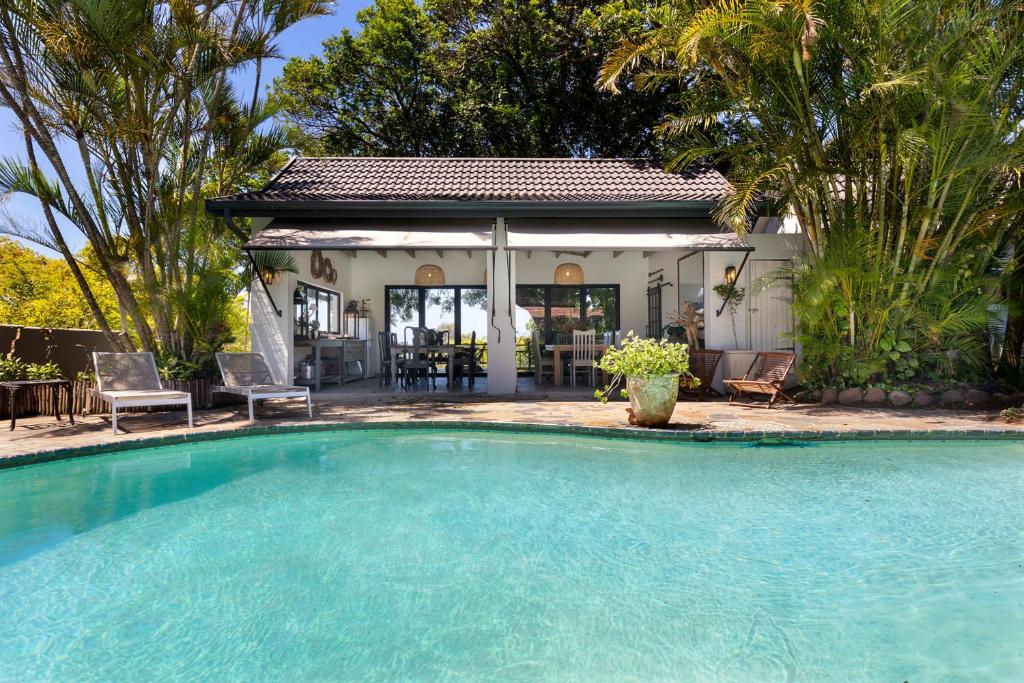 a swimming pool in front of a house at Seaforth Country House in Ballito