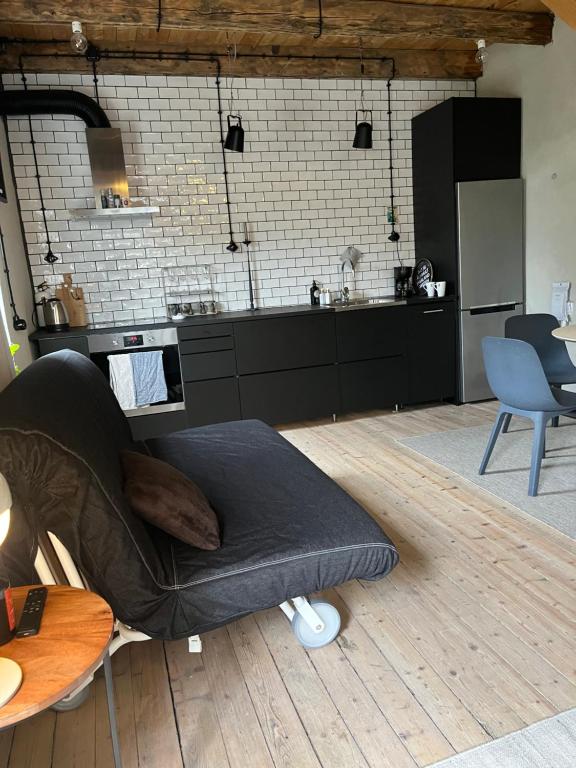 ein Wohnzimmer mit einem Bett auf einem Holzboden in der Unterkunft Lillahuset i Helsingborg! in Helsingborg