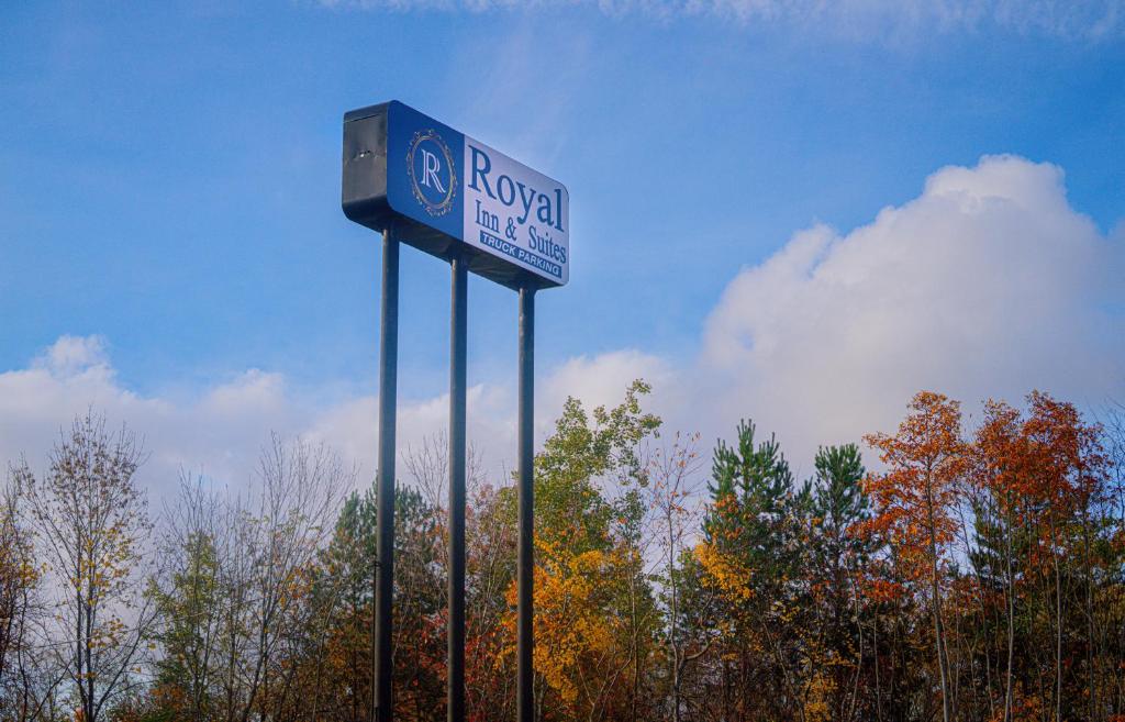 una señal para una estación de combustible raleigh frente a los árboles en Royal Inn & Suites, en Akron