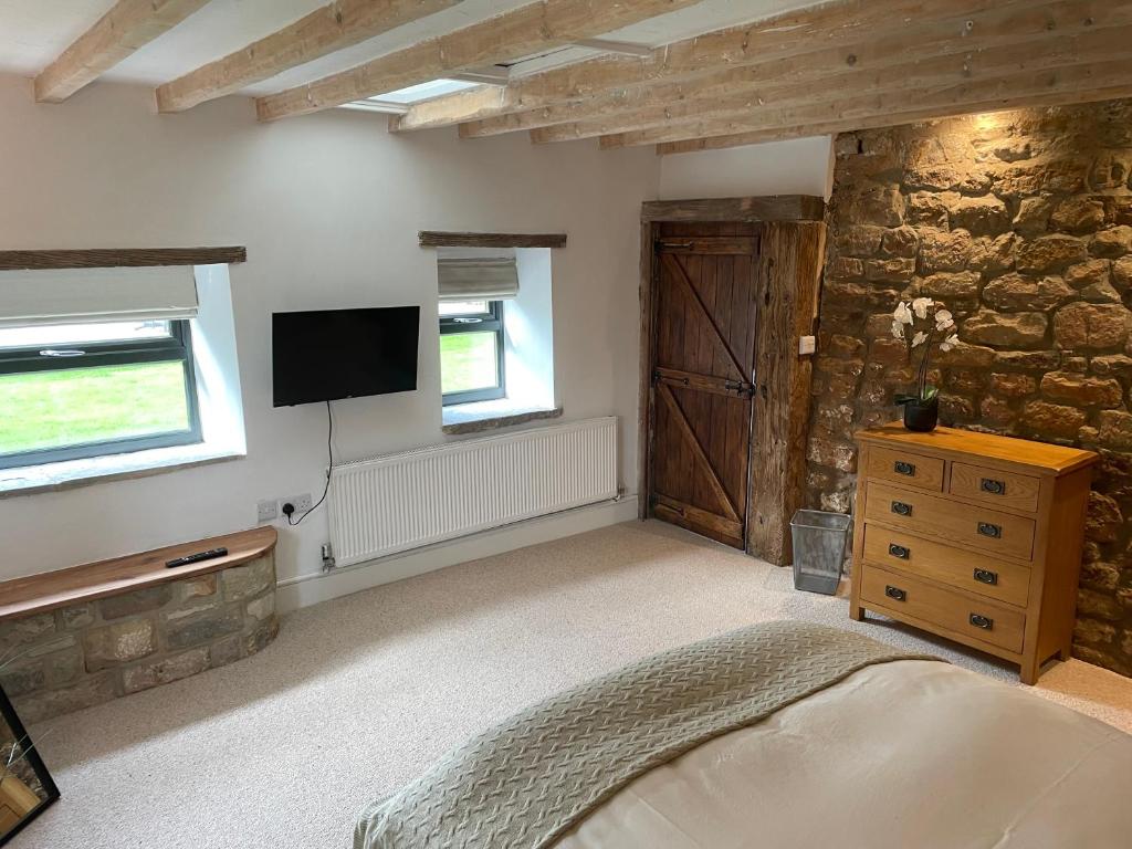 a bedroom with a bed and a tv on the wall at The Barn in Shirland