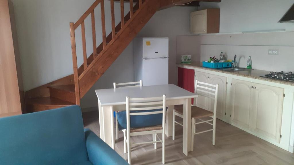 eine Küche mit einem Tisch und Stühlen sowie eine Treppe in der Unterkunft arborea in Marrùbiu