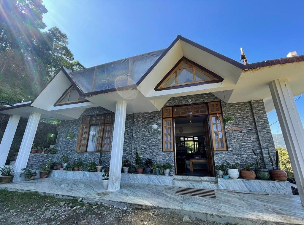 une maison avec une porte en verre et quelques plantes dans l'établissement Baralung homestay, à Mangpu