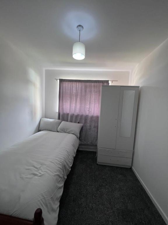 niewielka sypialnia z łóżkiem i oknem w obiekcie 7 Venus Road (Room 7) w Londynie
