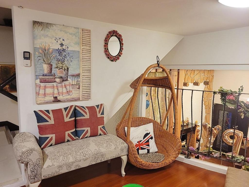a living room with a swing and a chair at British Country Inn B&amp;B in Luodong