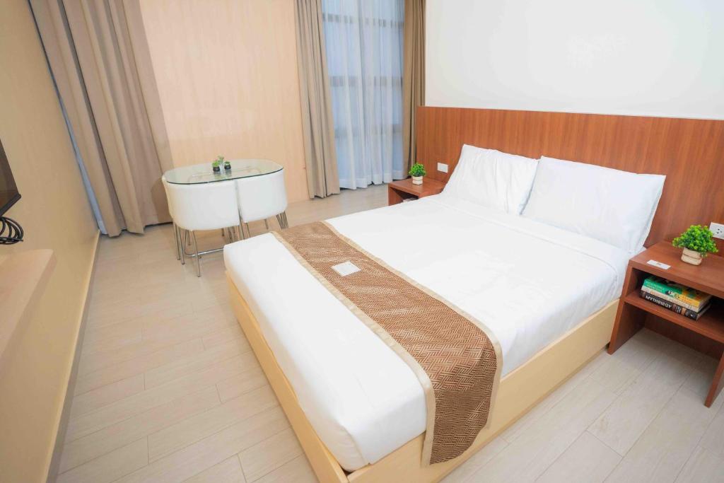 ein Schlafzimmer mit einem großen Bett und einer Badewanne in der Unterkunft Sundaze Dormitel in Naga