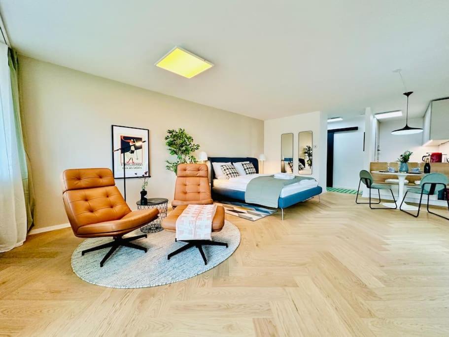 un soggiorno con letto, divano e sedie di Modern City Studio with Balcony a Zurigo
